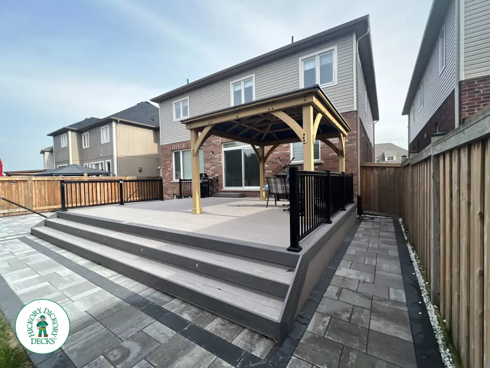 3 steps leading to a large Azek deck with lighting in the steps, and black aluminum railings.