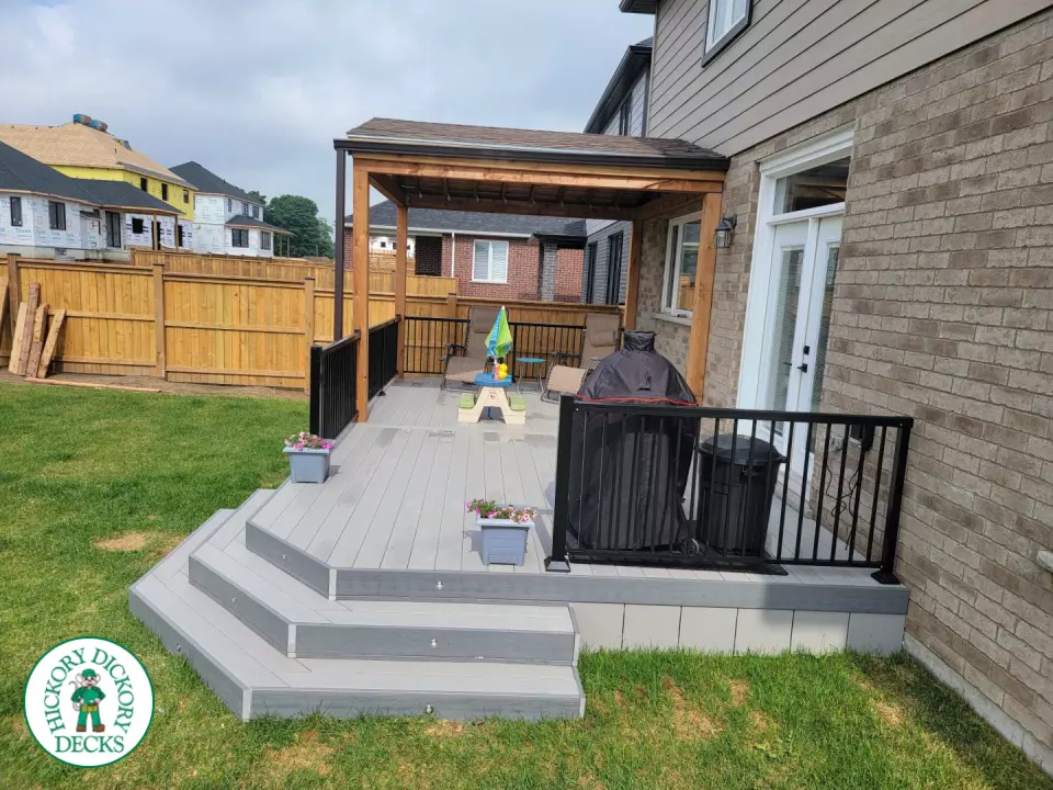 Large grey clubhouse deck with black aluminum railing and a custom cedar roof structure