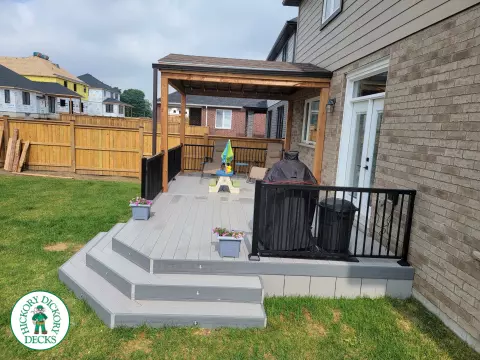 Large grey clubhouse deck with black aluminum railing and a custom cedar roof structure