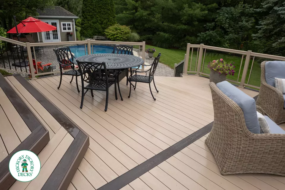 221 square foot light brown deck with dark brown border. This deck has curved steps and glass railings.