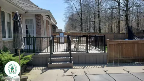 TruNorth composite deck in light grey color with three steps and black aluminum railing.