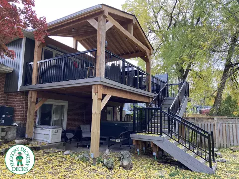 Mid-high deck brown TruNorth deck with lighting in steps and black aluminum railing all around.