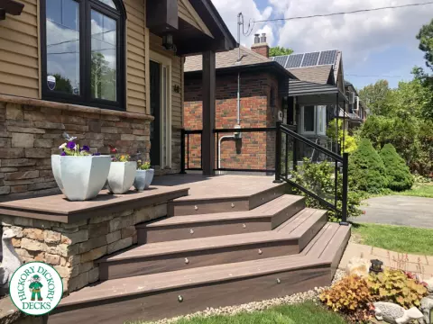 Brown porch with angled steps with lighting.