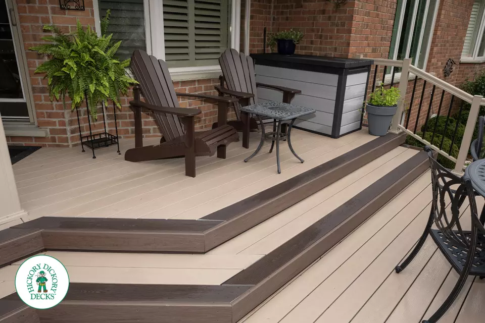 221 square foot light brown deck with dark brown border. This deck has curved steps and glass railings.