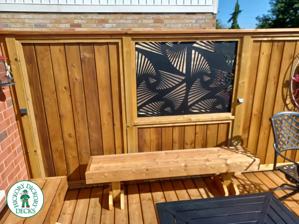 Mid rise pressure treated deck with glass railings, steps, and a custom cedar privacy screen
