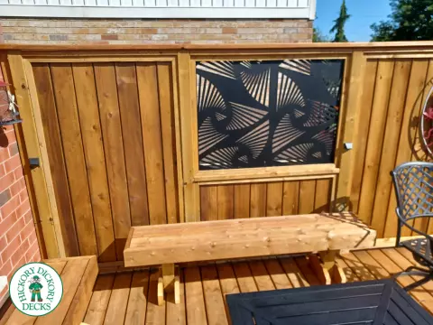 Mid rise pressure treated deck with glass railings, steps, and a custom cedar privacy screen