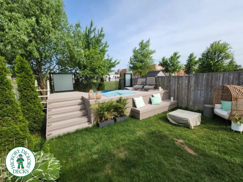 Grey Fiberon deck surrounding above ground pool with smoked glass railing.