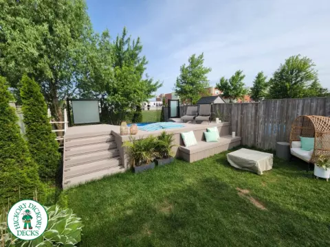 Grey Fiberon deck surrounding above ground pool with smoked glass railing.