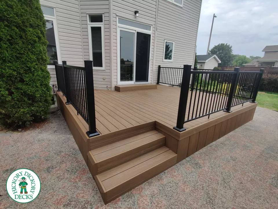 192 square foot fiberon in brown with three steps up to deck and black aluminum railing.