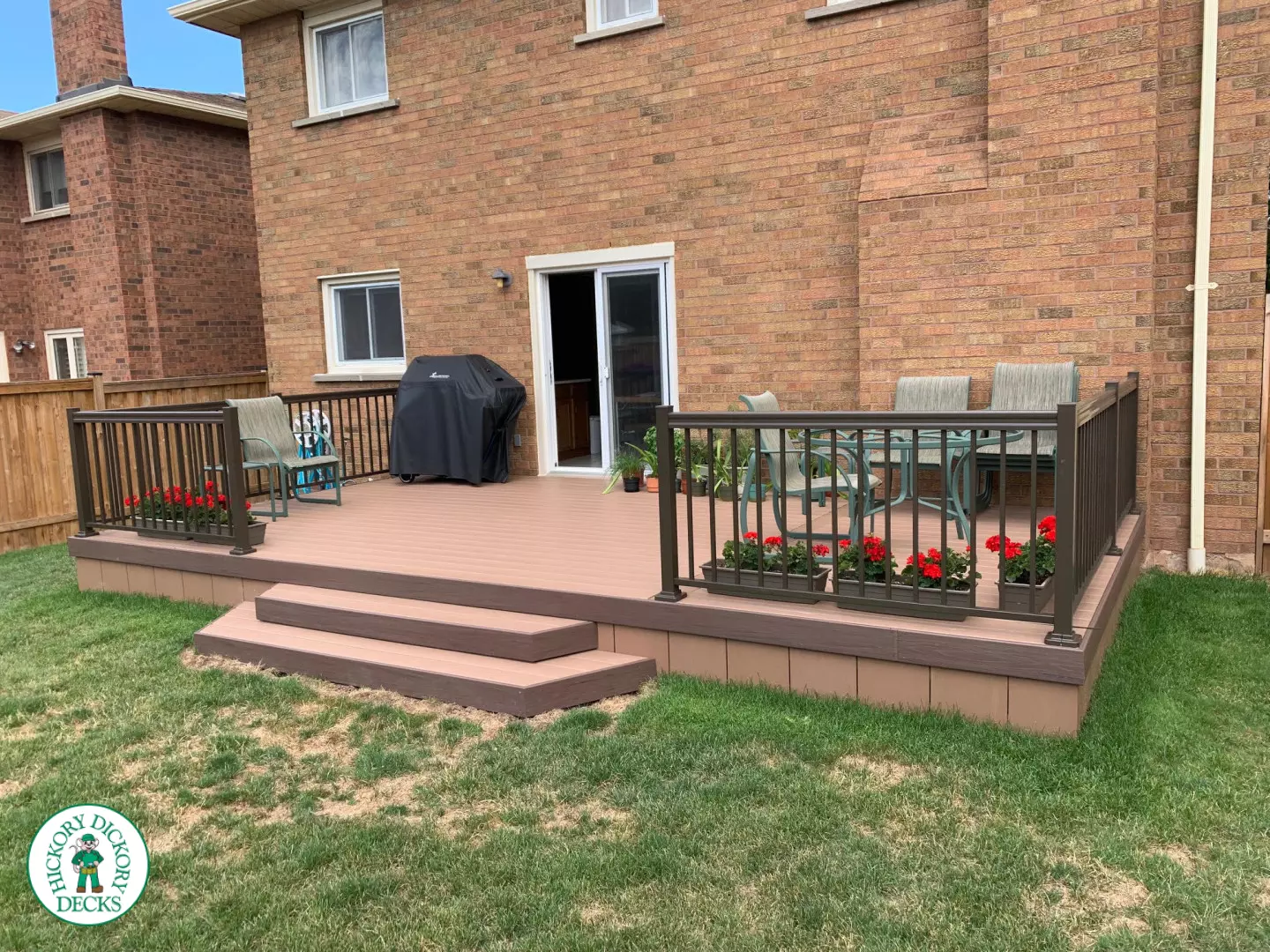 Small brown veka deck with two steps and aluminum railing.