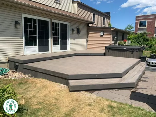 Low grey composite deck with no railing, one step up to deck and lights in steps.