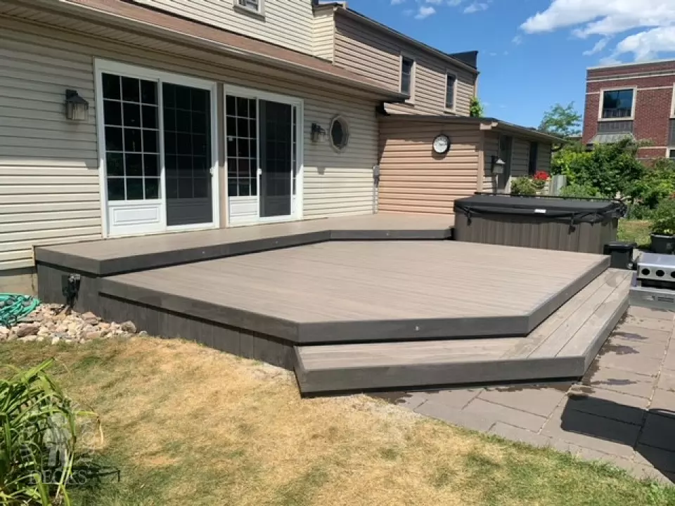 Low grey composite deck with no railing, one step up to deck and lights in steps.