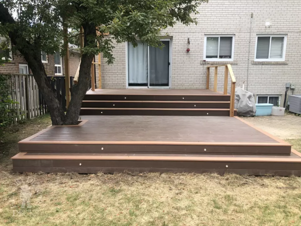 TruNorth deck with Mocha Caramel trim, wraparound steps, lights and a pergola, built around a tree. Etobicoke, Ontario