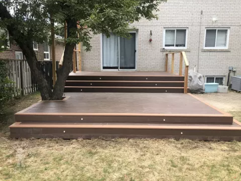 TruNorth deck with Mocha Caramel trim, wraparound steps, lights and a pergola, built around a tree. Etobicoke, Ontario