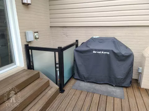 Large brown composite deck with pergola and unique stairs.
