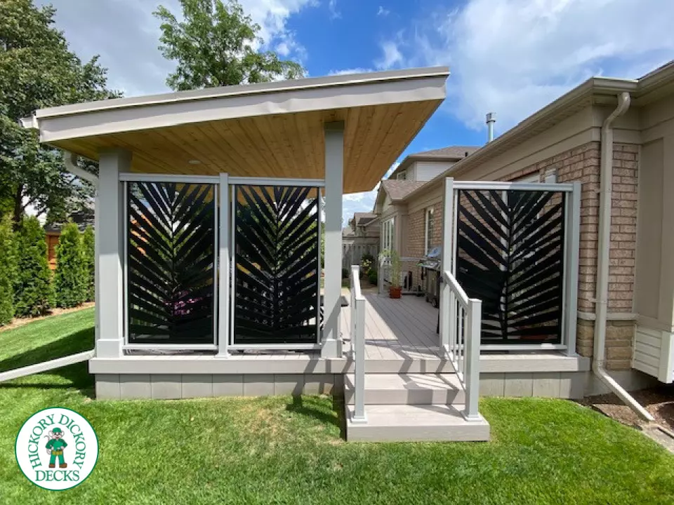 Low, small Azek deck with two steps up, lights in stairs, a custom privacy screen and a custom roof structure.
