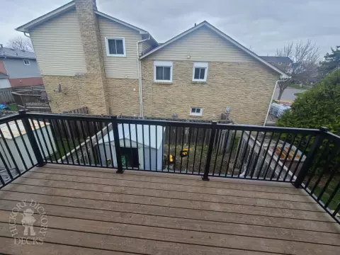 Dark brown Trex balcony with black aluminum railing.