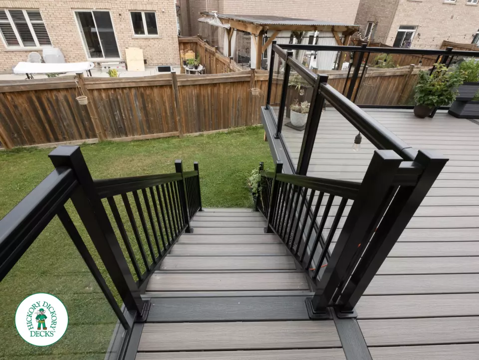 Elevated trex deck with glass railings and stairs in Brampton