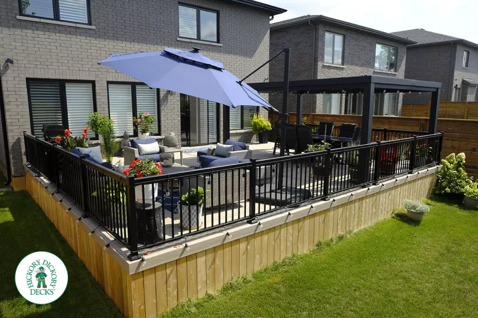 Large grey Fiberon walk out deck with black aluminum railings in Ancaster