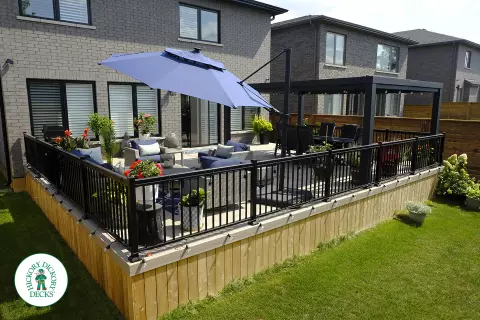 Large grey Fiberon walk out deck with black aluminum railings in Ancaster