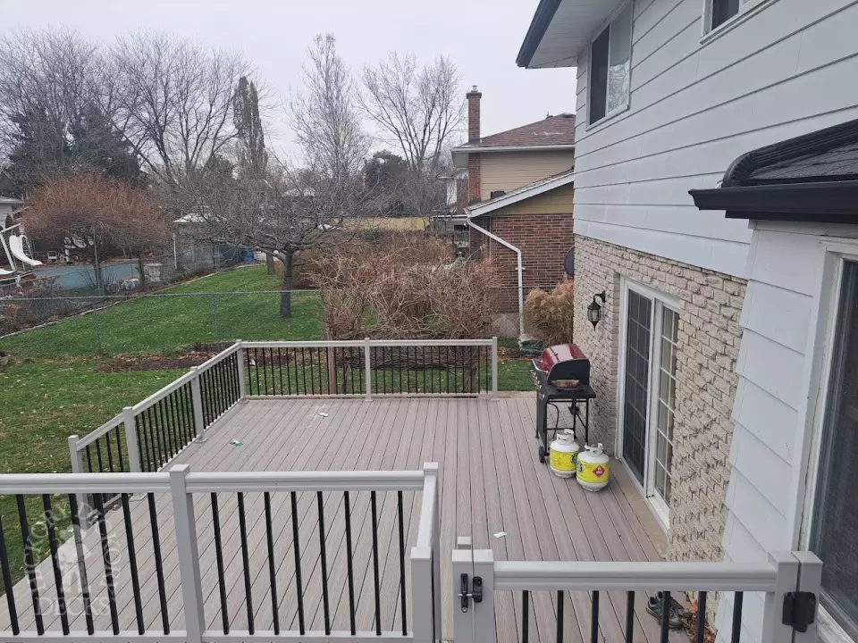 Two level grey Fiberon deck with beige picket aluminum railing and the top level surrounding an above ground pool.