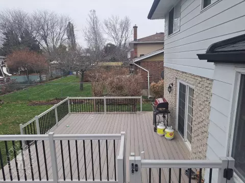 Two level grey Fiberon deck with beige picket aluminum railing and the top level surrounding an above ground pool.