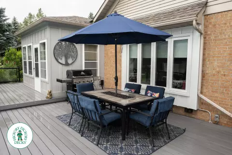 Large grey clubhouse deck with multi levels, lights in the steps, and glass railings.