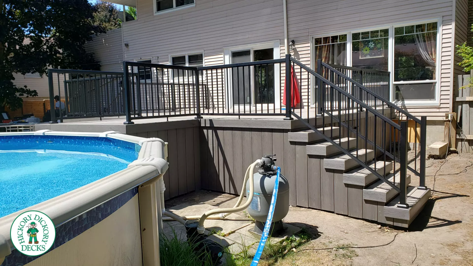 Grey above ground pool deck with black aluminum railings
