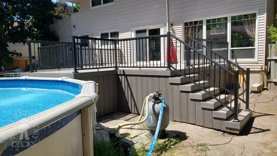 Grey above ground pool deck with black aluminum railings