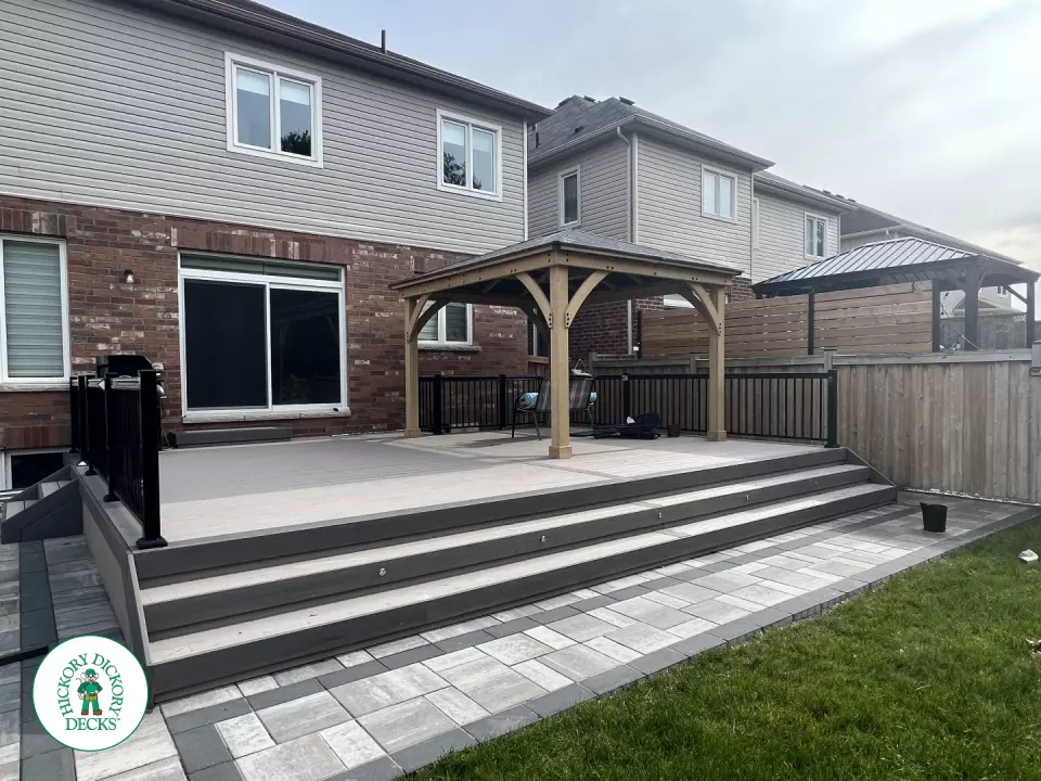 3 steps leading to a large Azek deck with lighting in the steps, and black aluminum railings.