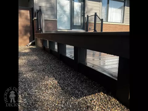Grey Clubhouse deck with dark grey border, lighting in steps, and a custom bench.