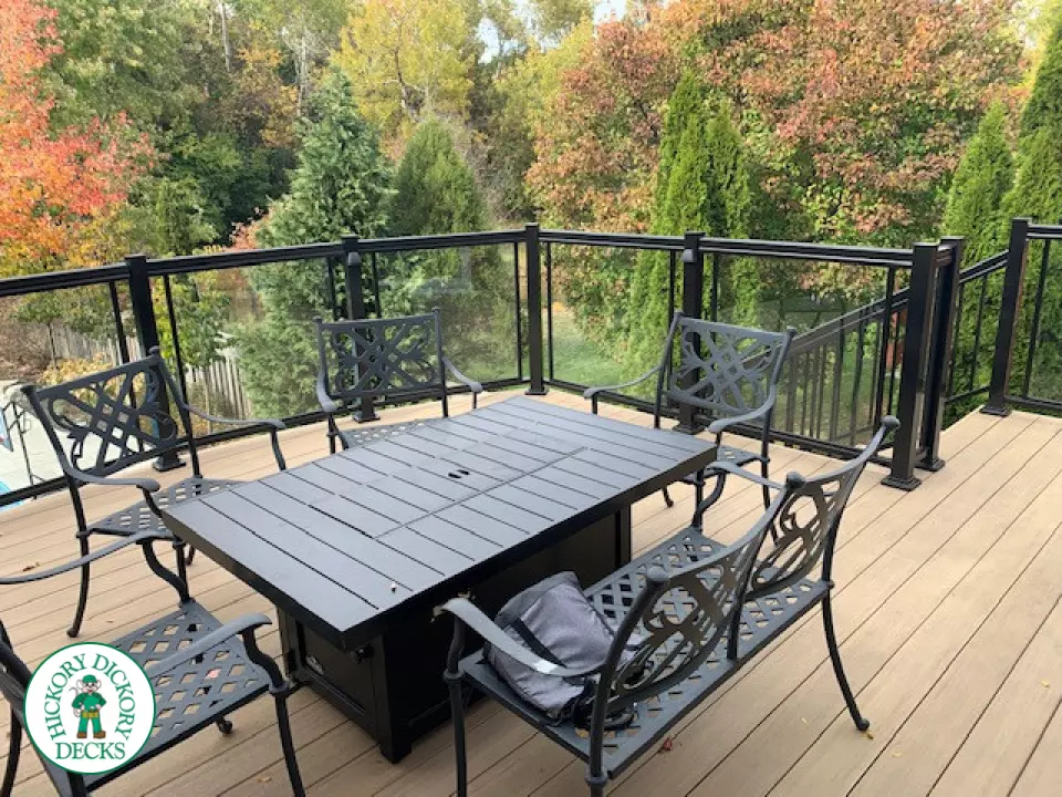 High composite deck with stairs that lead to pool and glass style railings.