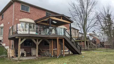 Large high Fiberon deck in brown. Glass railings and skylights in the custom roof structure.
