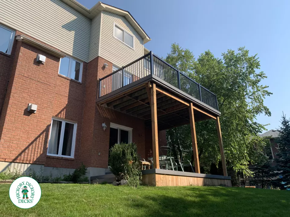Balcony and deck both in grey Fiberon, with black aluminum railing on balcony.