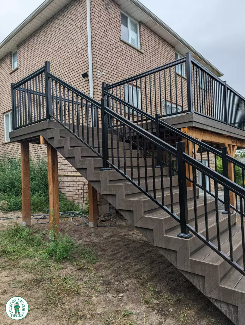 High clubhouse deck with stairs leading up to top, and black aluminum railing.