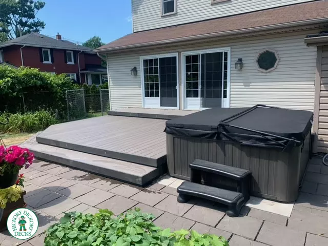 Low grey composite deck with no railing, one step up to deck and lights in steps.