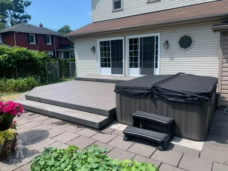 Low grey composite deck with no railing, one step up to deck and lights in steps.