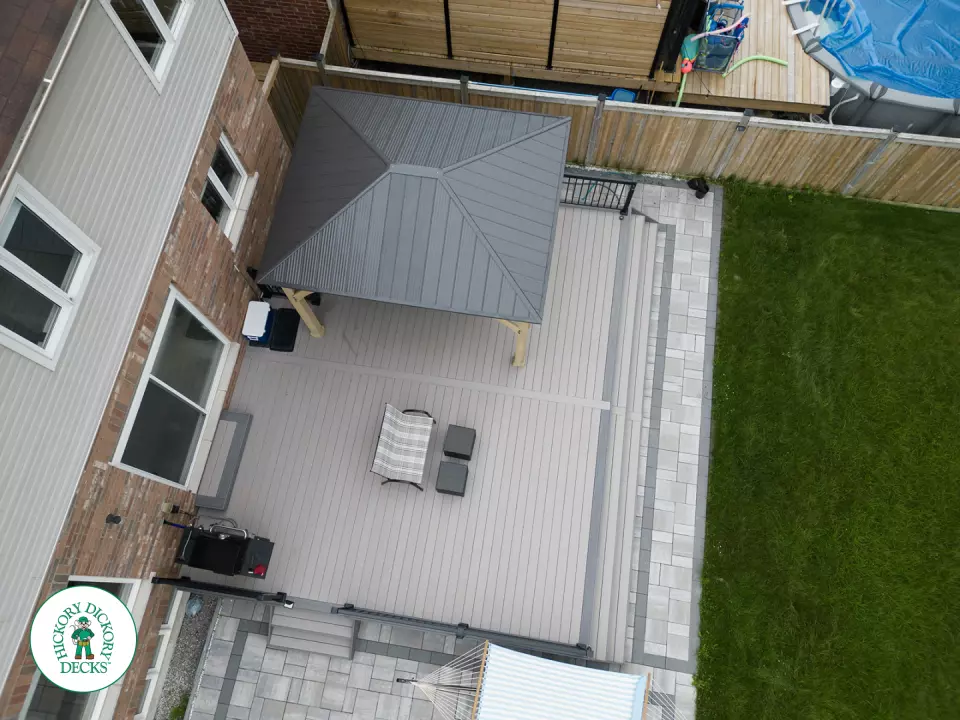 3 steps leading to a large Azek deck with lighting in the steps, and black aluminum railings.