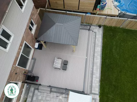 3 steps leading to a large Azek deck with lighting in the steps, and black aluminum railings.