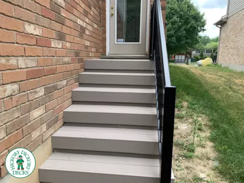 Mid size elevated deck built in grey composite with black railing.
