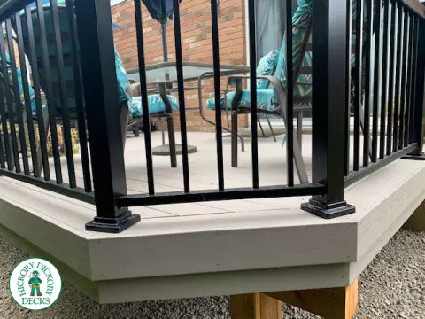 Mid size elevated deck built in grey composite with black railing.