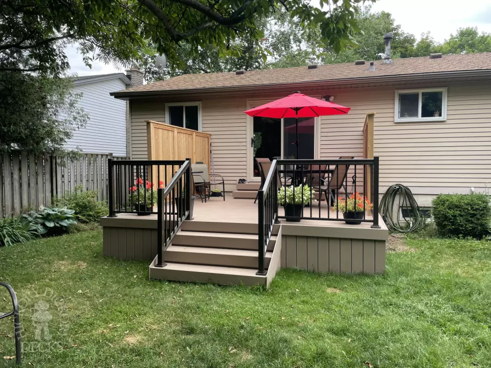 Small CLubhouse deck with four steps leading to backyard, black aluminum railing, and a cedar privacy screen.
