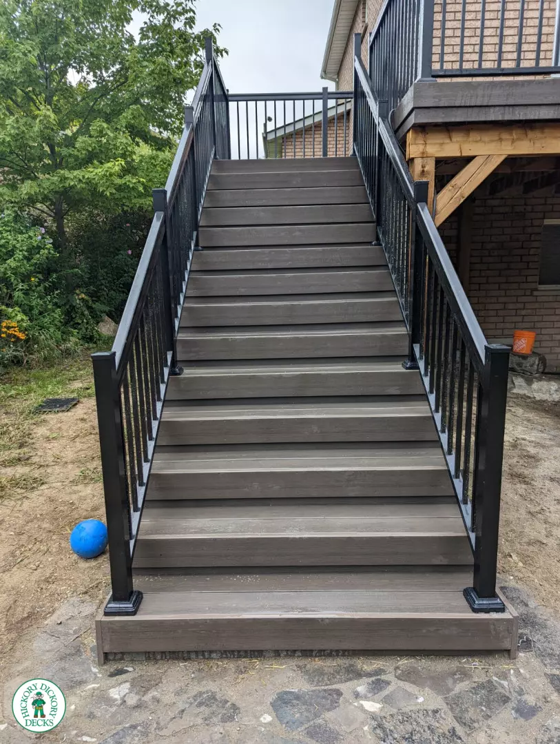 High clubhouse deck with stairs leading up to top, and black aluminum railing.