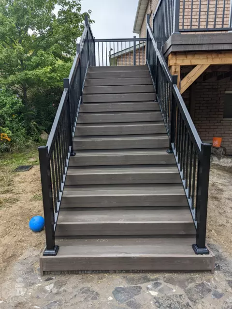 High clubhouse deck with stairs leading up to top, and black aluminum railing.
