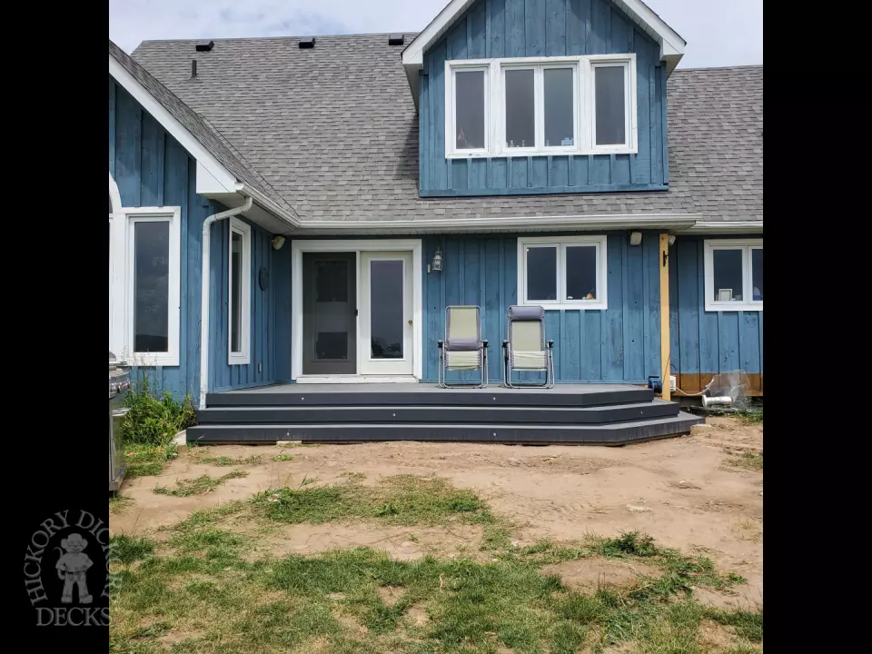 Small grey composite deck with angles steps leading to backyard