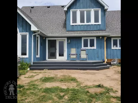Small grey composite deck with angles steps leading to backyard