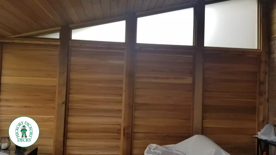 Low brown Veka deck with custom roof structure, black aluminum railing, and lights in steps.
