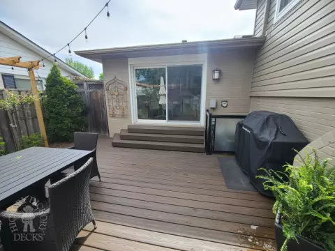 Large brown composite deck with pergola and unique stairs.