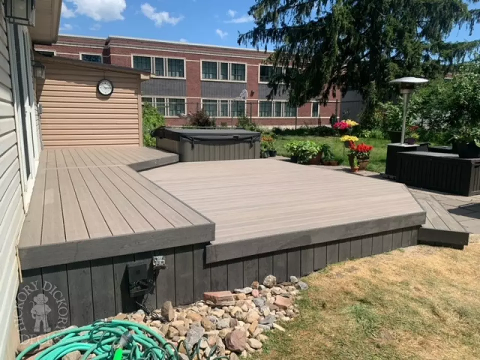 Low grey composite deck with no railing, one step up to deck and lights in steps.