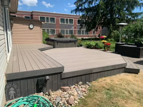 Low grey composite deck with no railing, one step up to deck and lights in steps.